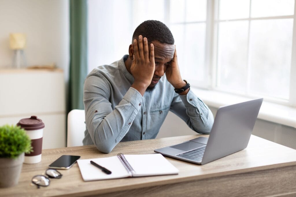 A man at work with his head in his hands looking stressed